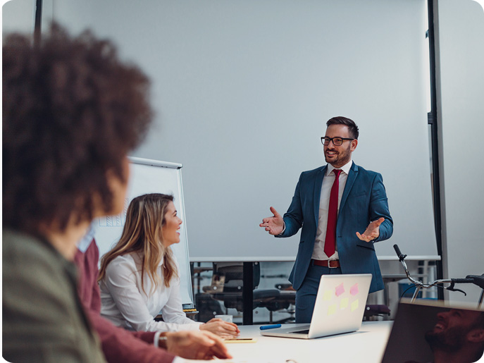 Growatt professional training, A business presentation with an individual gesturing towards colleagues around a conference table.