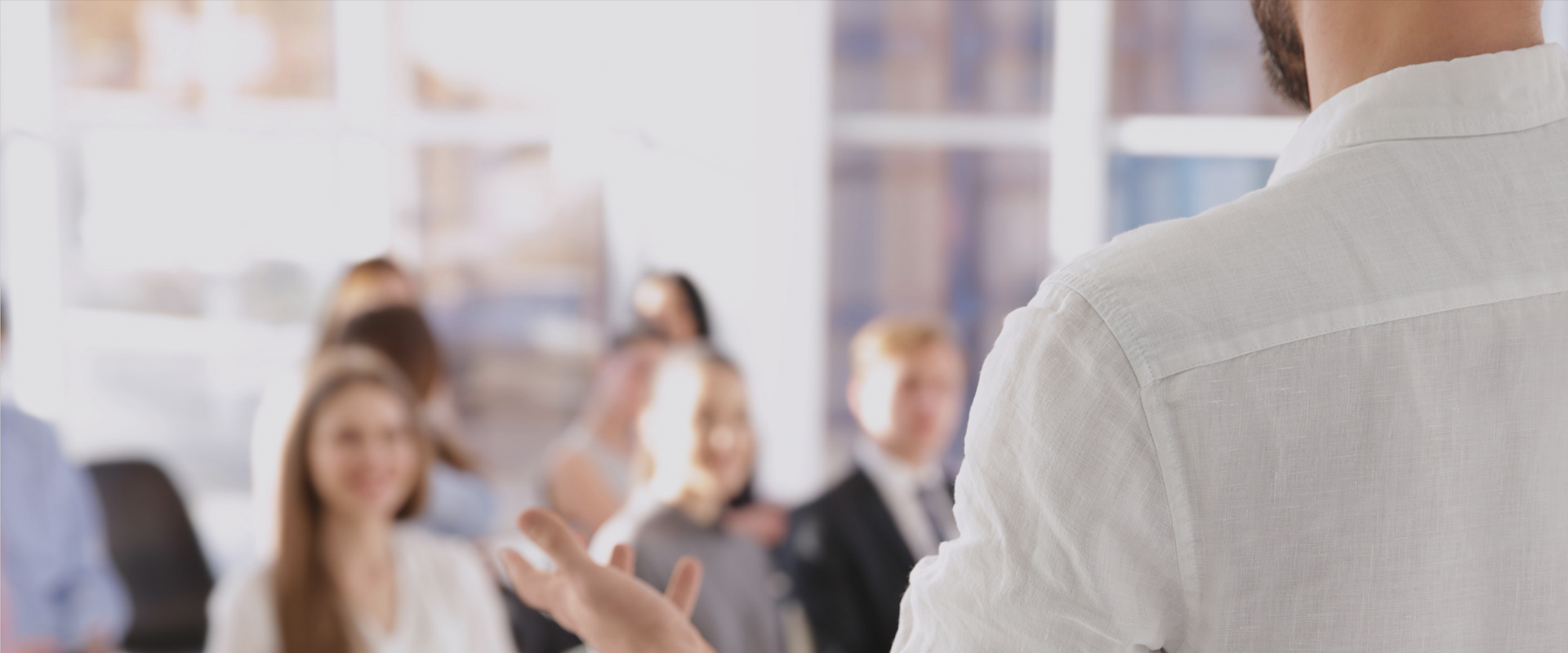 Growatt Online and Offline Training, Person in a white shirt gesturing with an outstretched hand to a group in a meeting room.